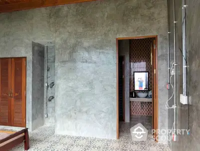 Modern industrial-style bathroom with concrete walls and patterned floor tiles.