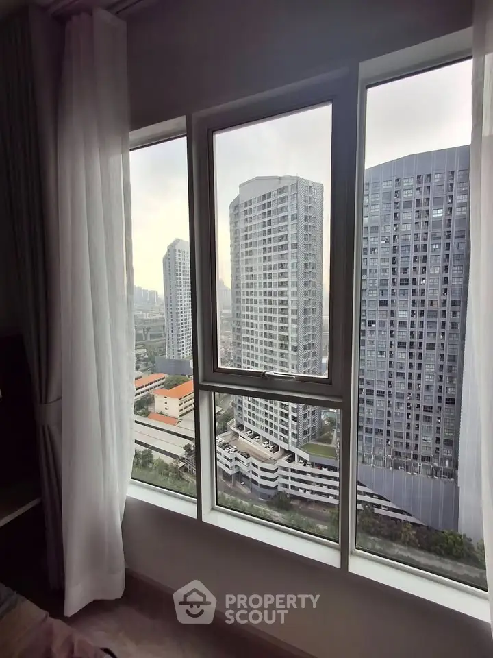 Stunning cityscape view from a modern apartment window, showcasing high-rise buildings and urban skyline.