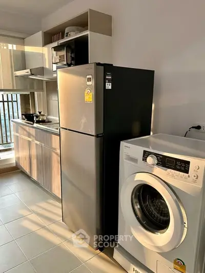 Modern kitchen with fridge and washing machine in a compact layout