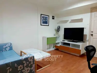 Cozy living room with modern furniture and TV setup, perfect for relaxation.