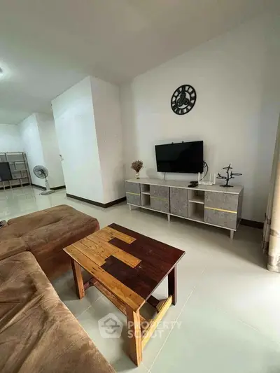 Modern living room with stylish furniture and wall-mounted TV