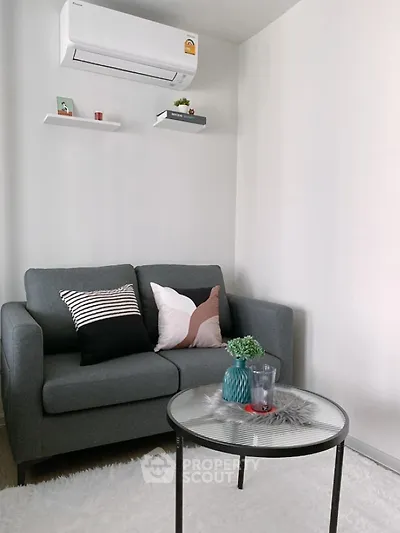 Cozy living room with modern sofa and air conditioning unit, perfect for relaxation.