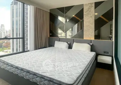 Modern bedroom with city view, featuring stylish wall design and large windows for natural light.