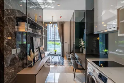 Modern living room with sleek design and natural light, featuring a washing machine and stylish decor.