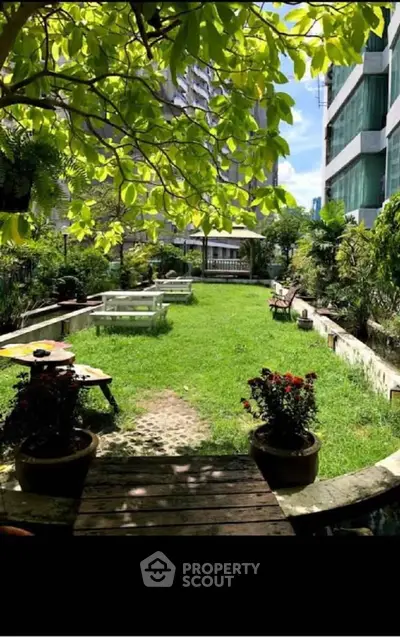 Lush garden area with seating in a modern residential complex, perfect for relaxation and outdoor activities.