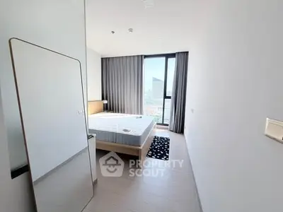 Modern bedroom with large window and city view, featuring minimalist decor and natural light.