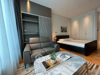 Modern studio apartment with stylish living area and cozy bed