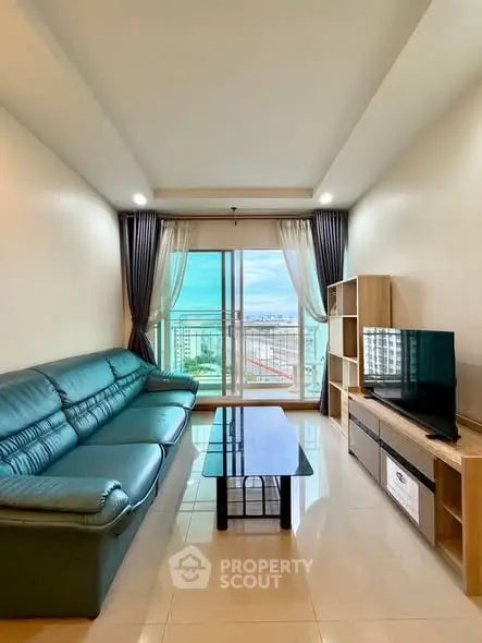 Spacious living room with modern furniture and stunning city view from large windows.