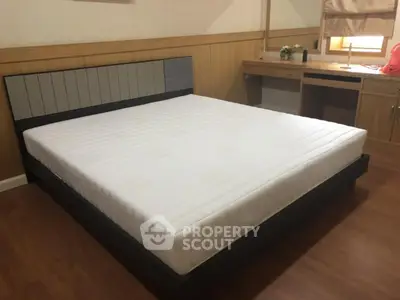 Spacious bedroom with modern bed and wooden flooring, ideal for comfort and relaxation.