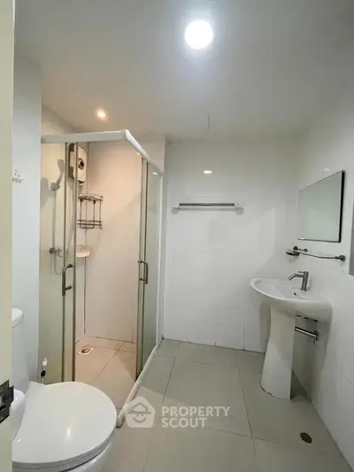 Modern bathroom with glass shower enclosure and sleek fixtures