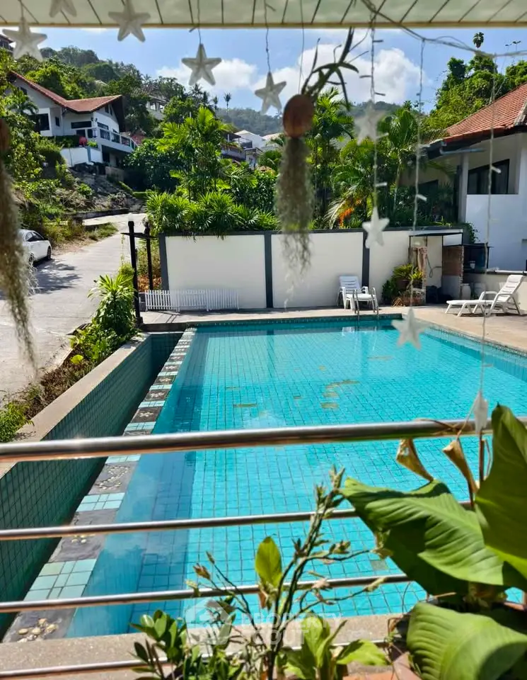 Charming poolside view with lush greenery and serene surroundings in a tropical setting.