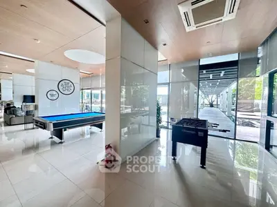 Luxurious recreation area with pool table and foosball, modern design and ample natural light.