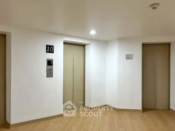 Modern building elevator lobby with two elevators and bright lighting.