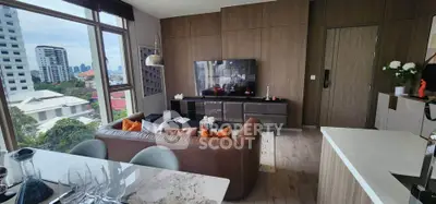 Modern living room with city view, stylish decor, and open layout in high-rise apartment.