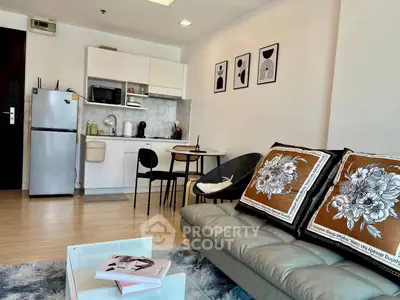 Modern living room with cozy seating and compact kitchen area.