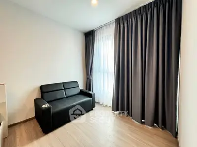 Modern living room with sleek black sofa and floor-to-ceiling curtains