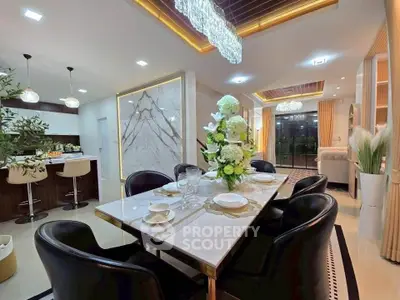 Luxurious open-plan dining and living area with elegant decor and modern lighting.