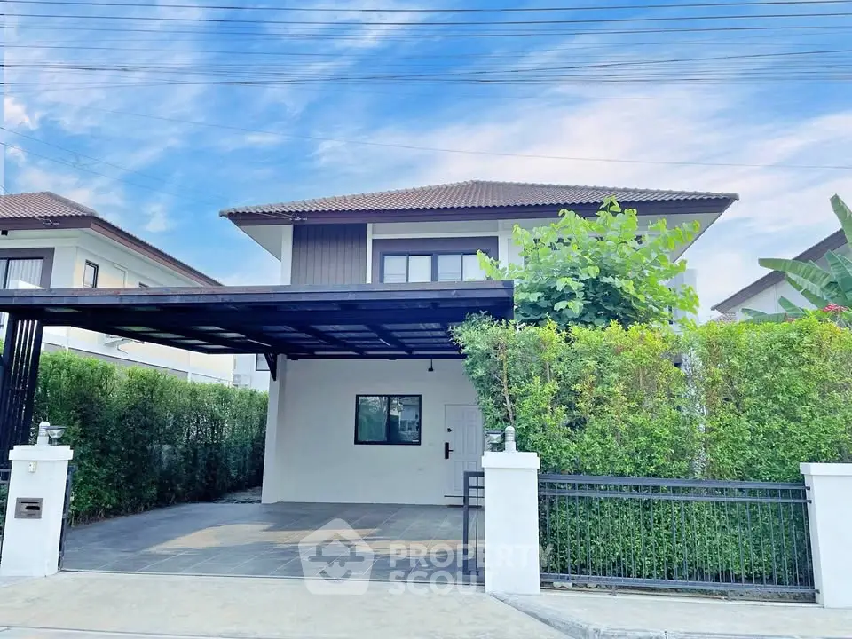 Charming two-story house with lush greenery and spacious driveway in a serene neighborhood.