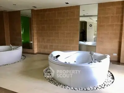 Luxurious spa-like bathroom with modern jacuzzi tub and elegant tile design.