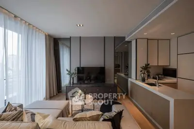 Luxurious modern living room with open kitchen and city view, featuring elegant decor and natural light.