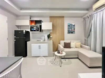 Modern living room with open kitchen, sleek furniture, and stylish decor in a cozy apartment.