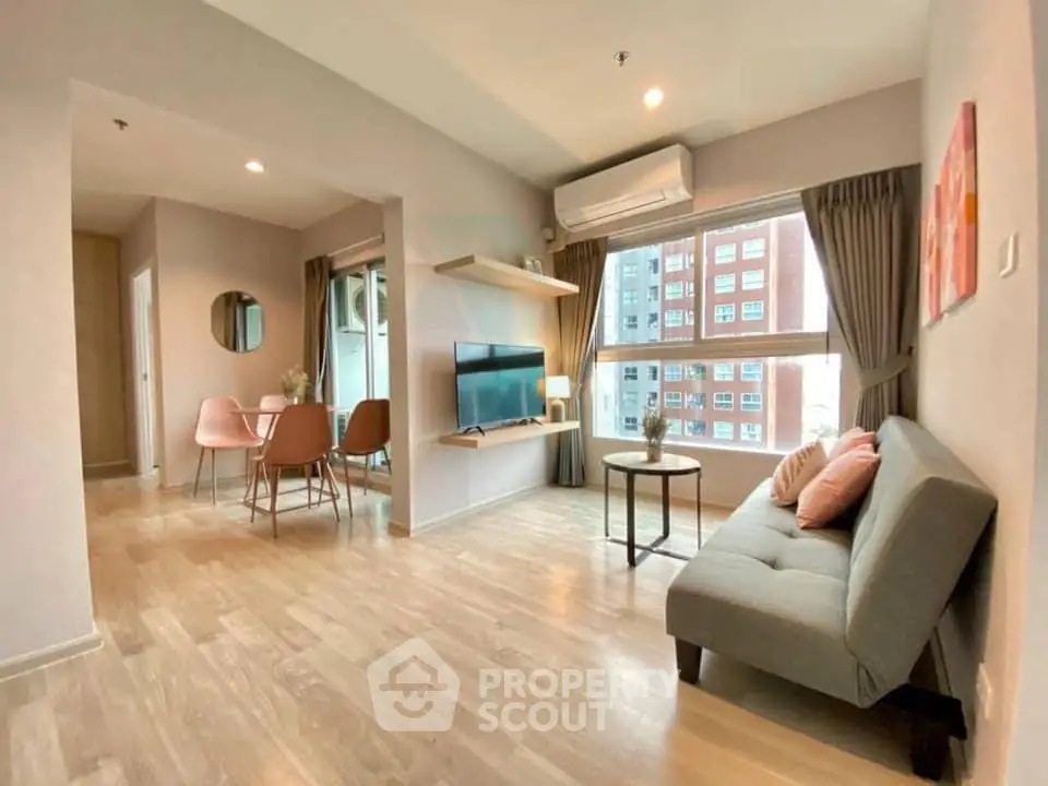 Modern living room with stylish decor and large windows offering city views