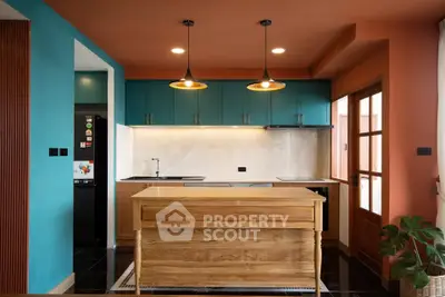 Modern kitchen with vibrant colors, wooden island, and stylish lighting