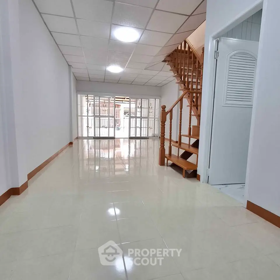 Spacious interior with elegant wooden staircase and bright natural lighting