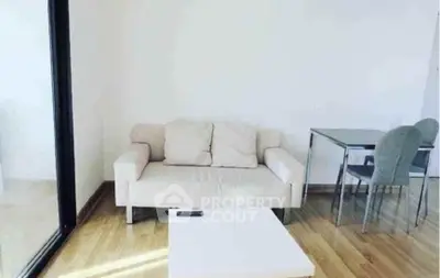 Modern minimalist living room with beige sofa and sleek dining set on wooden flooring.
