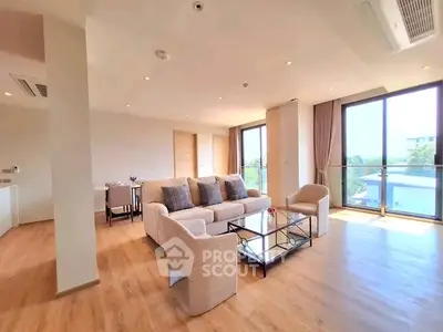 Spacious modern living room with large windows and elegant furnishings