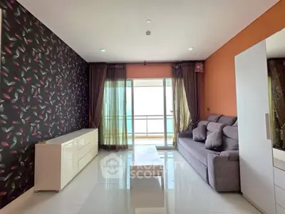 Spacious living room with modern decor and balcony access, featuring stylish wallpaper and sleek furniture.
