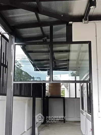 Modern covered entrance with sleek glass and metal design, perfect for contemporary homes.