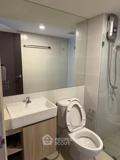 Modern bathroom with sleek fixtures and a glass-enclosed shower in a contemporary apartment.