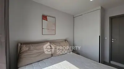 Cozy bedroom with modern decor and ample natural light, featuring a comfortable bed and sleek wardrobe.