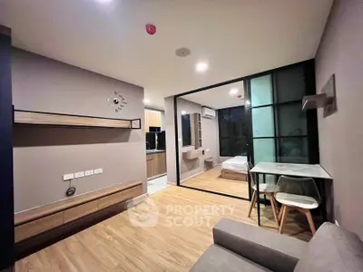 Modern open-plan living room with stylish decor and adjacent bedroom view