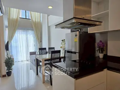 Modern open-layout kitchen and dining area with natural light and stylish decor.