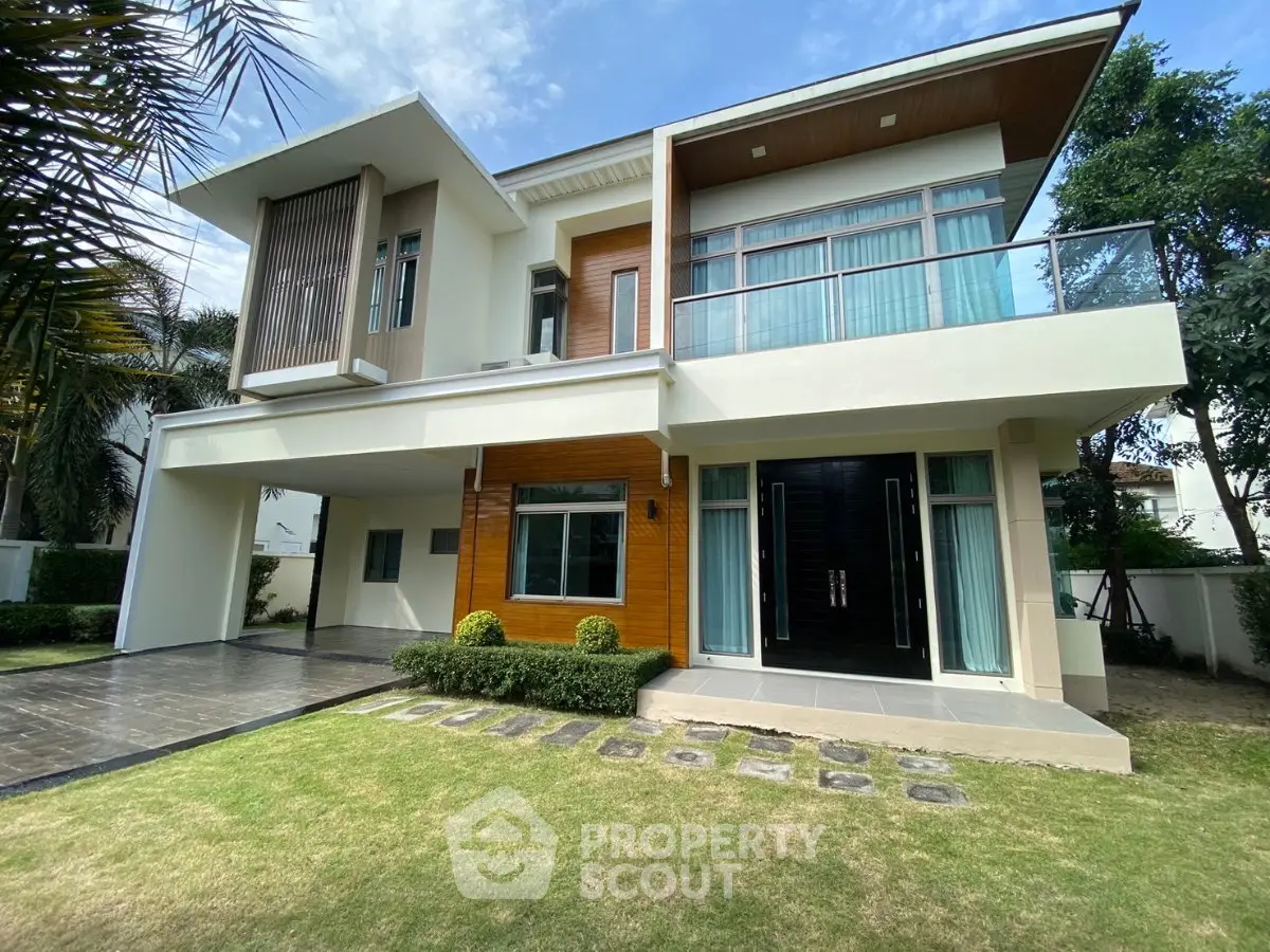 Modern two-story house with large windows and landscaped front yard