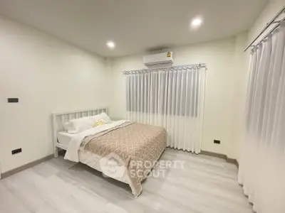 Cozy bedroom with modern decor and air conditioning in a bright, inviting space.