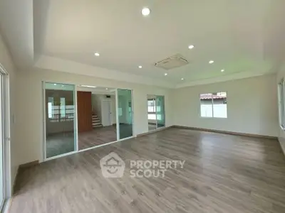 Spacious modern living room with wooden flooring and large windows