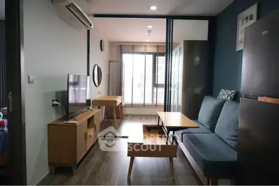 Modern living room with stylish furniture and natural light, featuring a cozy sofa and sleek wooden accents.