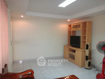 Spacious living room with modern entertainment center and tiled flooring