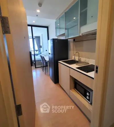 Modern compact kitchen with sleek appliances and open layout in urban apartment