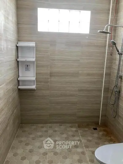 Modern bathroom with sleek shower and tiled walls, perfect for a contemporary home.