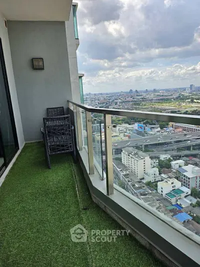 Stunning high-rise balcony with panoramic city views and artificial grass flooring.