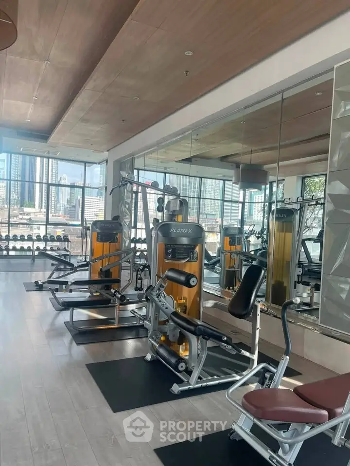 Modern gym with state-of-the-art equipment and city view, perfect for fitness enthusiasts.