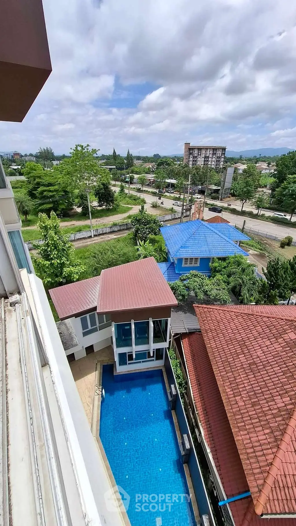 Stunning aerial view of residential complex with pool and lush greenery, perfect for serene living.