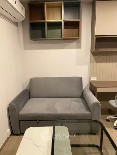 Modern living room with stylish grey sofa and wall-mounted shelves