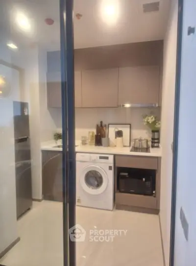 Modern kitchen with washing machine and sleek cabinetry