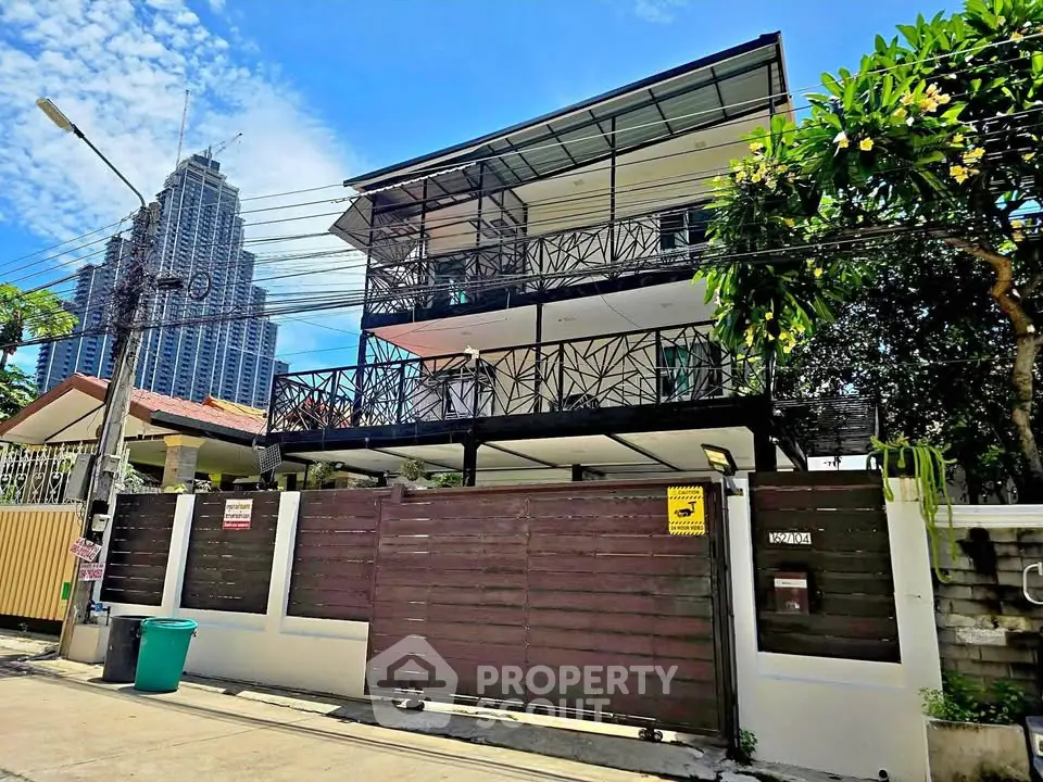 Modern three-story building with unique facade design and lush greenery, perfect for urban living.