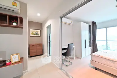 Modern apartment interior with bedroom and study area, featuring sleek design and natural light.